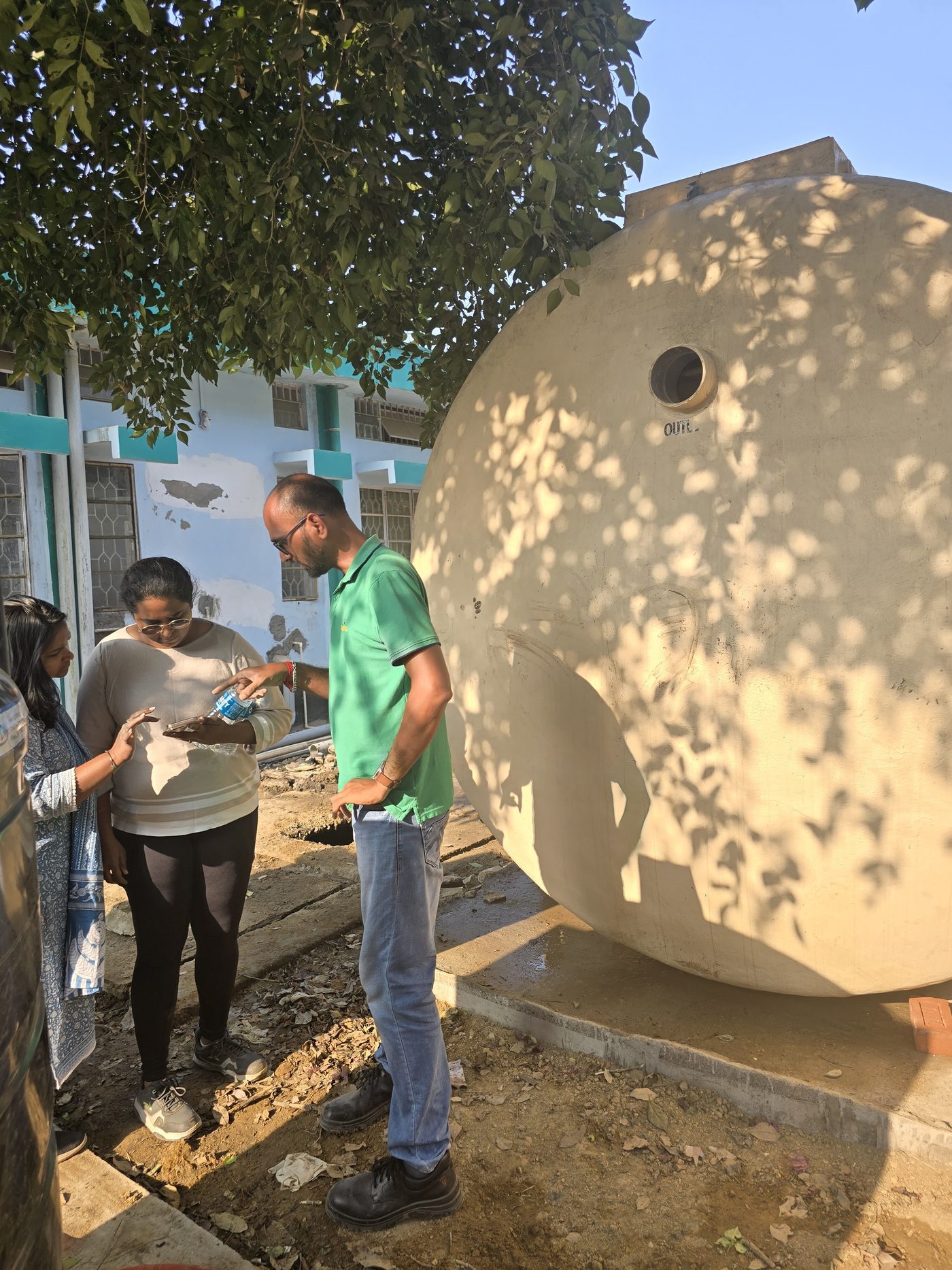 Team members checking details beside the tank.